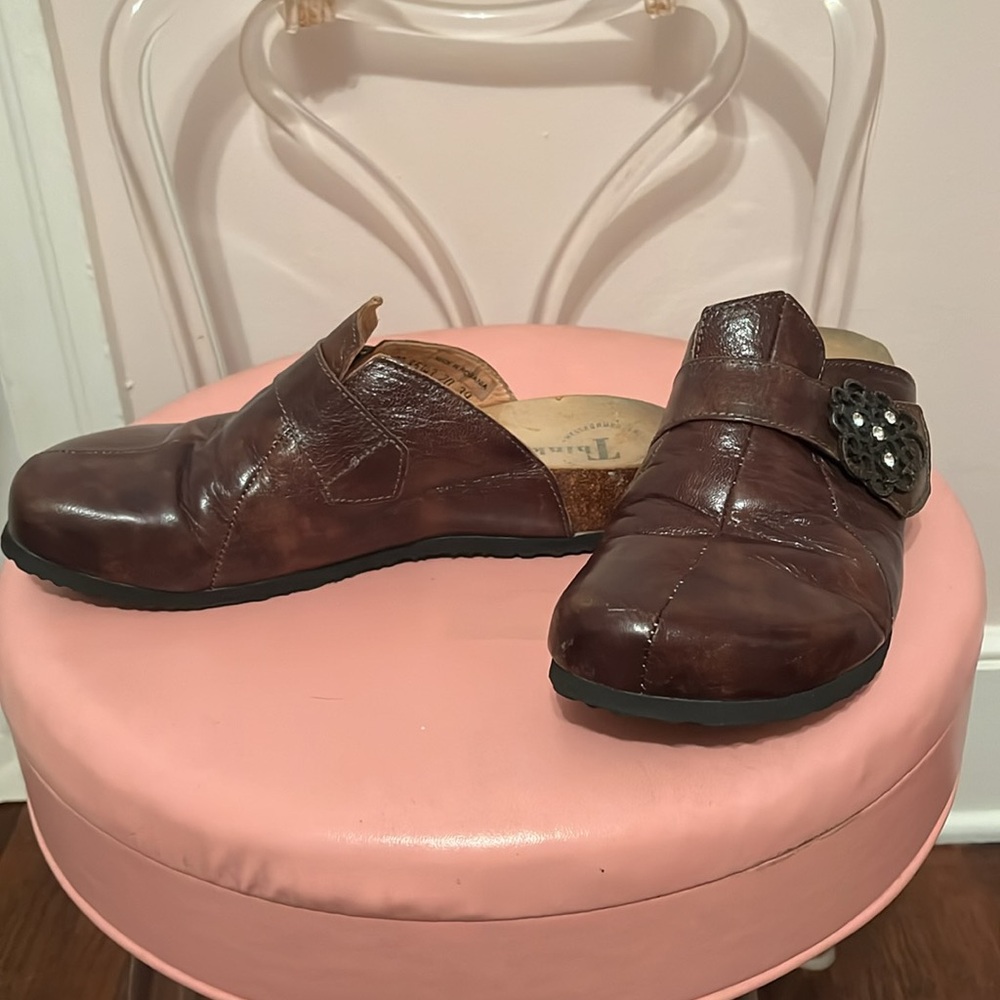 Brown leather Think! clogs with decorative buckle.